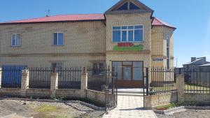 a brick house with a fence in front of it at Hostel Americana in Astana