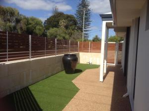 a balcony with green grass and a fence at Carpe Diem South in Busselton