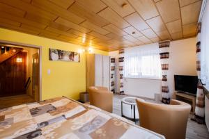 a dining room with a table and chairs and a television at Boxis Ferienhaus in Probstzella
