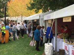 a crowd of people standing in line at a farmers market at bluebird cottage in Angaston