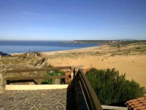 een uitzicht op een strand met een houten hek en de oceaan bij panato's home in Torre Dei Corsari