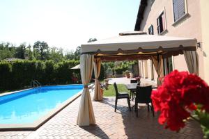 a table and chairs under an umbrella next to a pool at Villa Gilda in Bracciano
