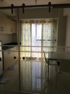 a kitchen with a glass table and a window at Matlocs @ Wind Residences in Tagaytay
