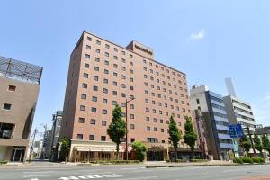 um grande edifício numa rua da cidade com uma estrada em Richmond Hotel Hamamatsu em Hamamatsu