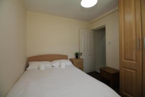 ダブリンにあるStoneybatter Self Catering Apartmentのベッドルーム1室(白いベッド1台、枕2つ付)