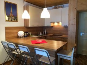 a kitchen with a wooden table and chairs at Innerkrems Apartment Mateja in Innerkrems