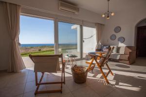 sala de estar con sofá, mesa y sillas en Kamiros Apartment en Kalavárda