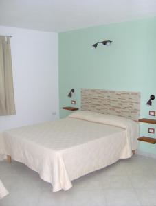 トルトリにあるCamping Cigno Biancoのベッドルーム1室(ベッド1台、壁に照明2つ付)