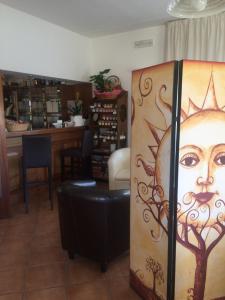 un magasin avec une porte peinte d'un visage dans l'établissement Hotel Girifalco, à Massa Marittima