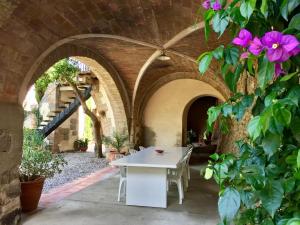 un patio al aire libre con una mesa blanca y flores en Apartaments Can Gibert, en Castelló d'Empúries