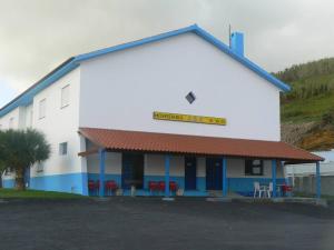 un edificio blanco y azul con un cartel en él en Hotel JSF, en Horta