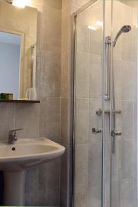 a bathroom with a sink and a shower at LOGIS -Hotel & Restaurant de la Place in Aunay-sur-Odon