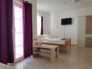 a room with a bed and a table and a tv at Apartment Patrizia in Zadar