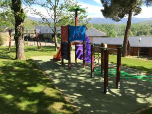 un parc avec une aire de jeux avec un toboggan dans l'établissement Cabañas Maleixas, à El Puente