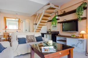 a living room with a white couch and a tv at Duplex El Manantial in El Puerto de Santa María