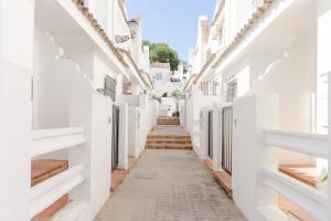 a narrow alley between white buildings at Duplex El Manantial in El Puerto de Santa María