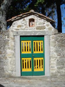 a building with a green and yellow door at Castello di Sarna in Chiusi della Verna