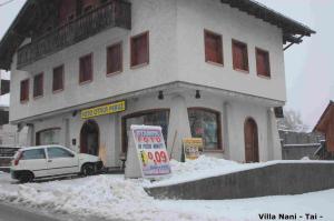 a white car parked in front of a building in the snow at Villa Nani in Pieve di Cadore