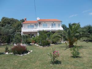a large house with a palm tree in a yard at Apartments Makaus in Rab