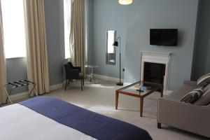 a bedroom with a bed and a couch and a fireplace at Yarrow Hotel in Broadstairs