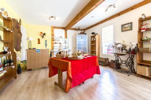 uma cozinha com uma mesa com uma toalha de mesa vermelha em Les Roulottes-Gîtes de la Ferme de l'Autruche Dromoise em Livron-sur-Drôme