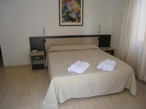 una camera da letto con un letto e due asciugamani di Hotel Canasta a Rimini