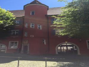 a large red brick building with an arch doorway at Ferienwohnung Alte Schmiede in Vogtsburg