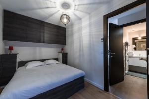 een slaapkamer met een groot bed en een badkamer bij La Clé des Champs in Annecy