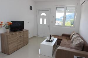 a living room with a couch and a tv at Guest House Ugljevarevic in Budva