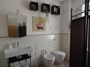ein Badezimmer mit einem Waschbecken, einem WC und einem Spiegel in der Unterkunft B&B Bergamo e Brescia in Rodengo Saiano
