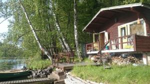 een hut op het water met een boot voor de deur bij Lohja Chalet at Lake Enäjärvi in Karjalohja