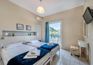 a hotel room with two beds and a window at Argyro Rent Rooms in Kritsa