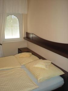 1 dormitorio con 1 cama con cabecero y ventana en Kentaur Apartmanház en Siófok