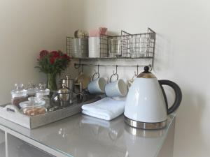 a glass table with a tea kettle and dishes on it at Church Combe - Petworth West Sussex in Petworth