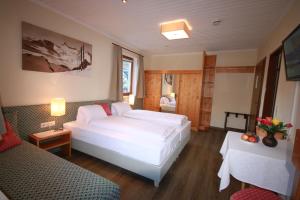 ein Schlafzimmer mit einem weißen Bett und einem Sofa in der Unterkunft Haus Alexander in Schladming