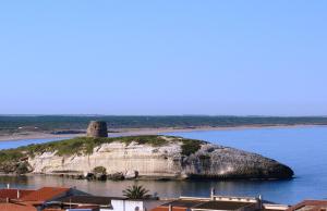 an island in the water with a tower on it at Hotel Bellavista S'Archittu in S'archittu Cuglieri