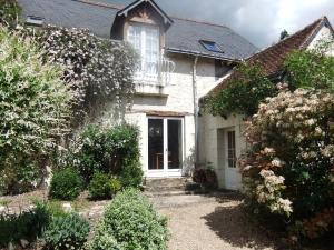 a white house with a white door and some bushes at Le Moulin De Saussaye in Crouzilles