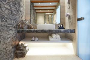 a bathroom with a sink and a mirror at Vrahos Boutique Hotel in Karavostasi