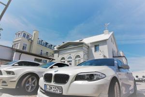 a white car parked in front of a white house at Villa Promenada in Międzyzdroje