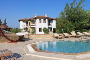 una piscina con sillas y una casa en Villa Mercan, en Datça