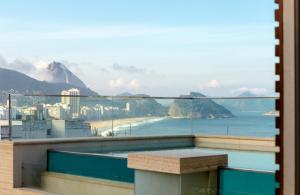 a balcony with a view of the ocean and mountains at Ritz Copacabana Boutique Hotel in Rio de Janeiro