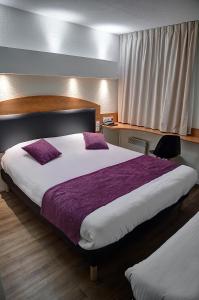 um quarto de hotel com duas camas e uma janela em Logis Le Relais de Sassenage em Sassenage