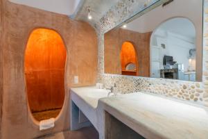 a bathroom with two sinks and a mirror at Eleni's Village Suites in Klouvas