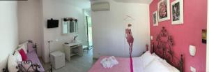 ヌマーナにあるGiglio Del Coneroのピンクの壁のベッドルーム(ベッド1台付)
