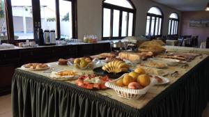 a table with many different types of food on it at Hotel das Figueiras in São Lourenço do Sul