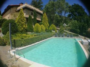 uma piscina com cadeiras e uma casa em Palacio de Trasvilla em Escobedo