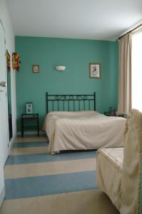 a bedroom with a bed and a blue wall at Hôtel Bertrand in Bar-le-Duc