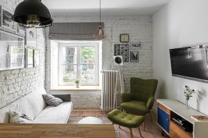 ein Wohnzimmer mit einem Sofa und einem TV in der Unterkunft Mariensztat Apartment in Warschau