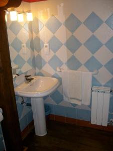 a bathroom with a sink and a blue and white tiled wall at Casa Rural La Torre de Espinama in Espinama +23 photos