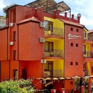 a red and yellow building with a sign on it at Виктория Созопол in Sozopol